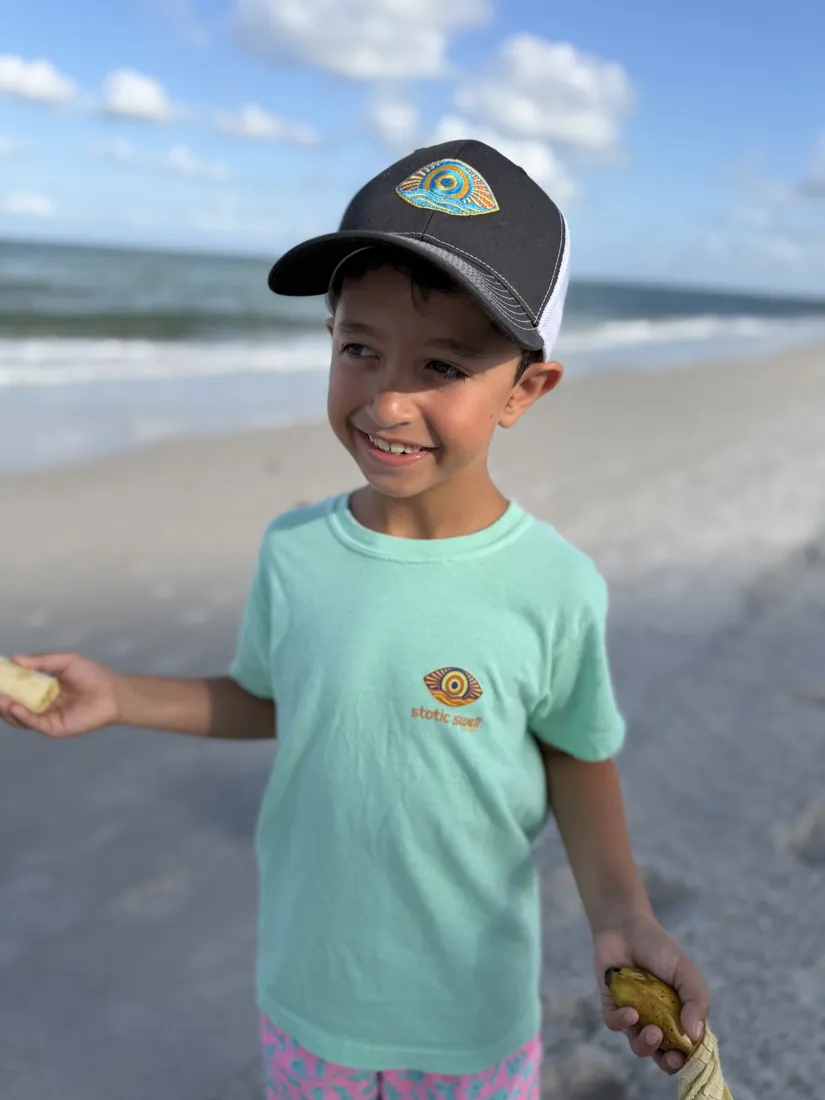 A Static Swell youth tee on the beach