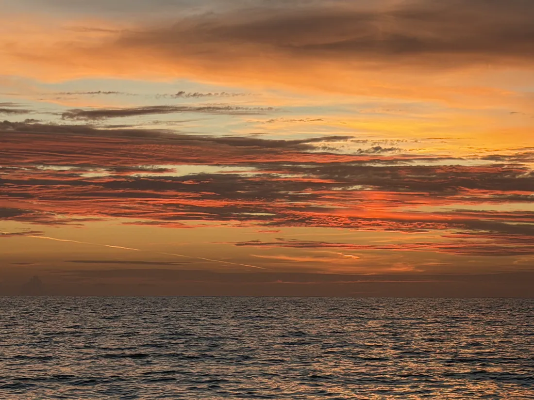 Cloud bands over the water at sunset